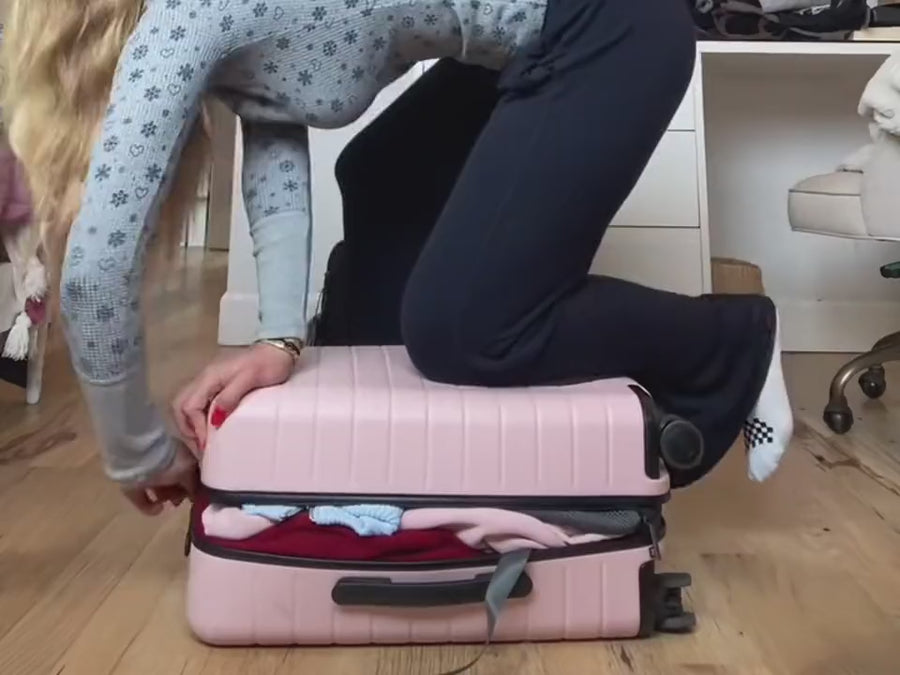 Kneeling on an overstuffed expandable carry-on